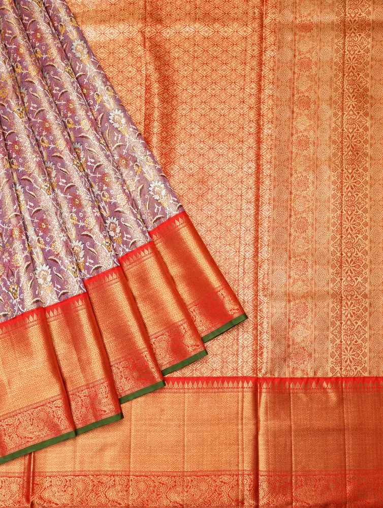Close-up of a purple and gold Kanchipuram silk saree with woven peacock motif border