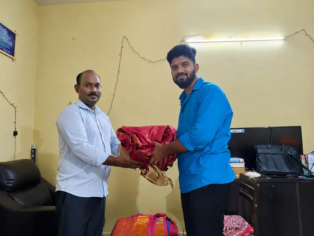 Our team receiving a folded silk saree from a customer at their office