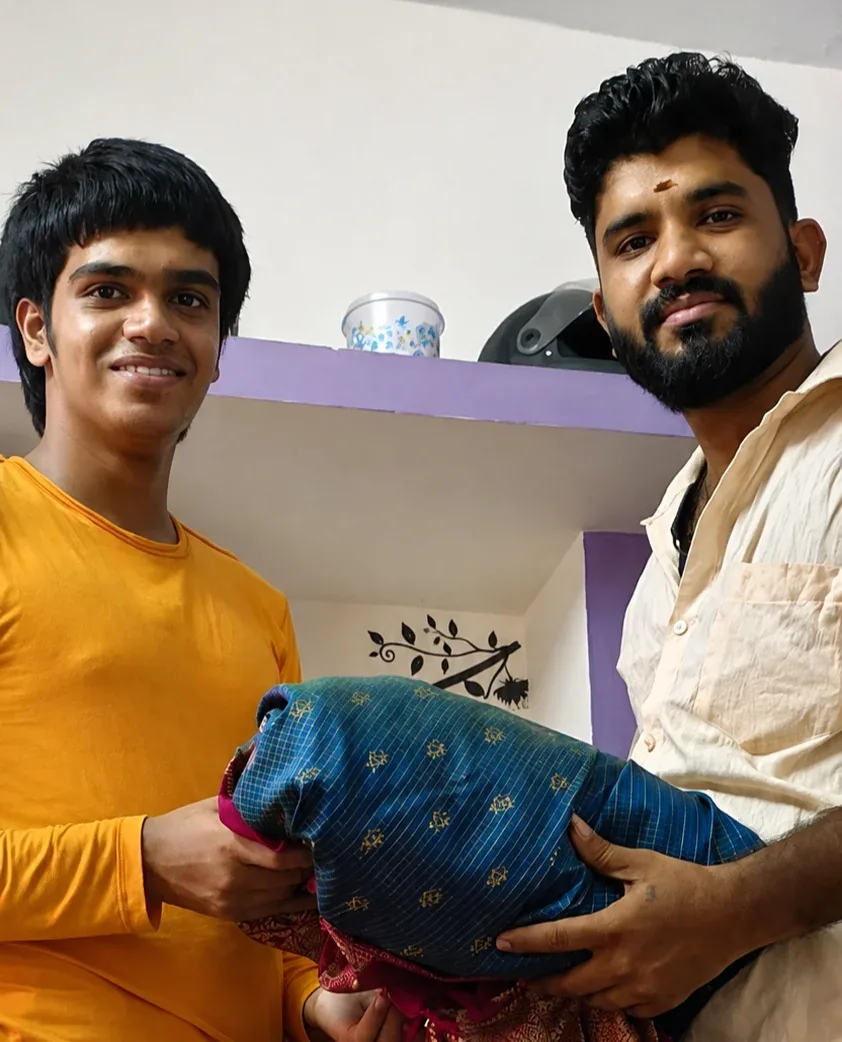 Two customers handing over a blue and pink silk saree