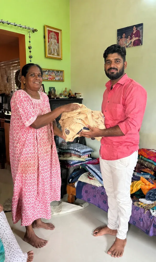 Customer handing over a golden silk saree to our team