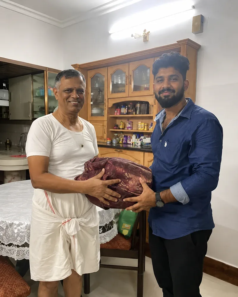 Customer handing over a maroon silk saree to our team