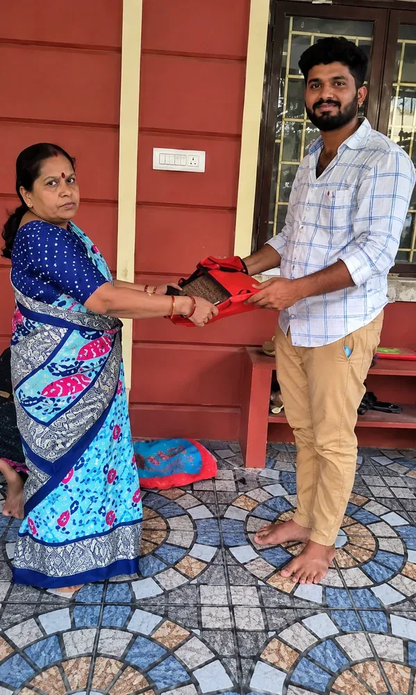 Customer handing over a saree to our team at their doorstep