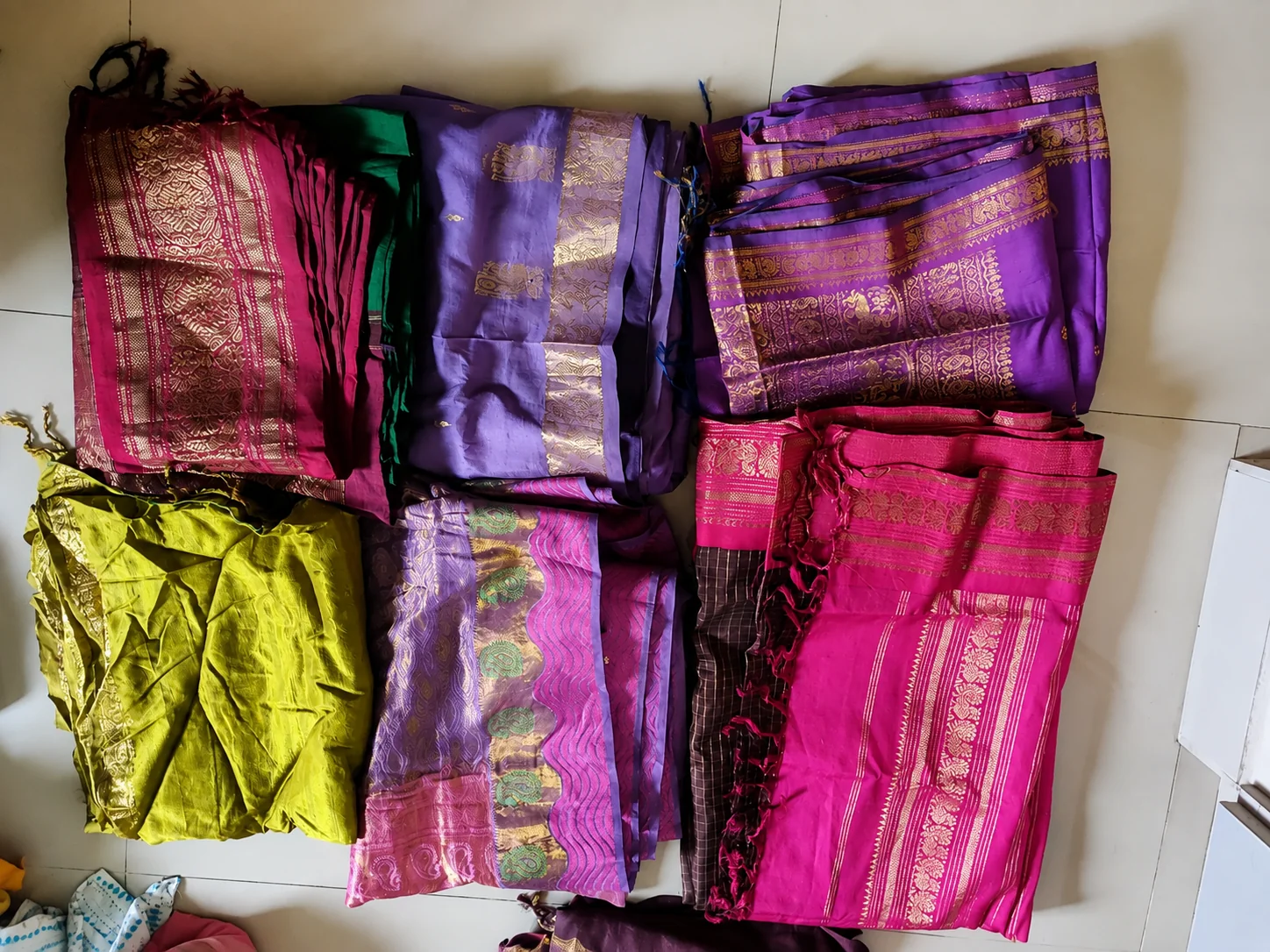Old pattu saree buyers in Chennai — sorted pile of pink, purple and green silk sarees