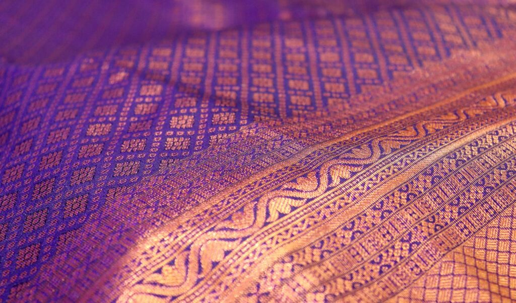 Close-up of a traditional Kanchipuram silk saree, showcasing intricate patterns and vibrant colors.